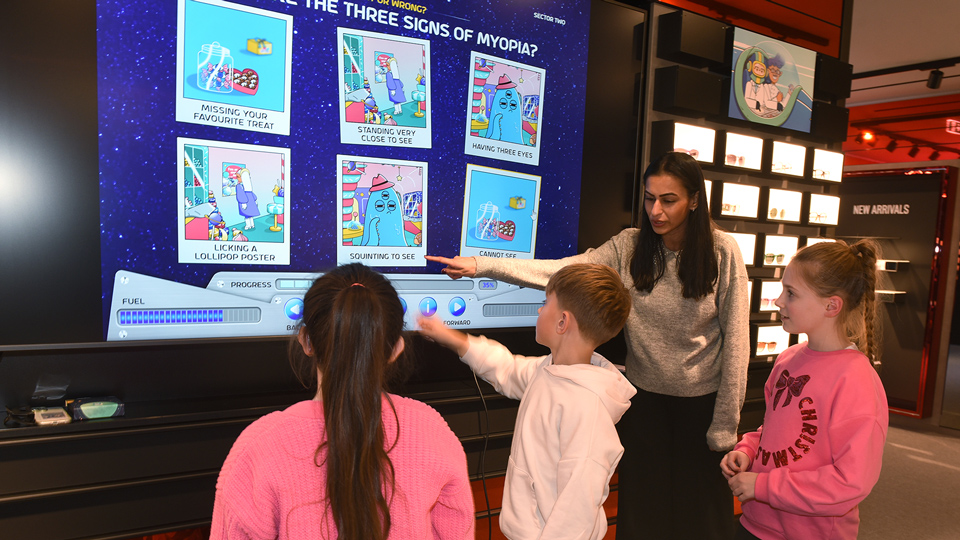 Amisha Pau leads three children through an interactive activity illustrated with a cute blue alien character 