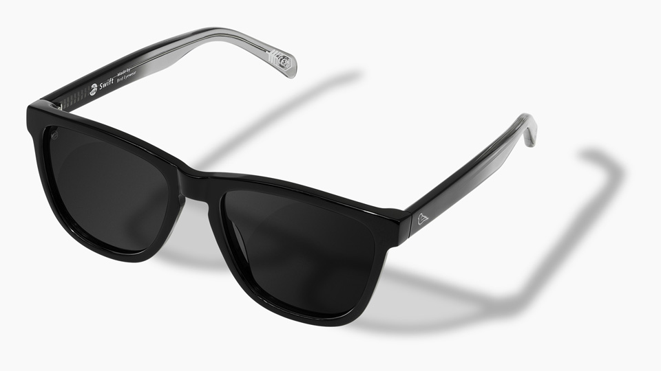 A pair of black square sunglasses with arms that feature a gradient from black to clear  