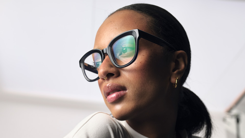 A stylish image of a woman posing with large dark sunglasses 