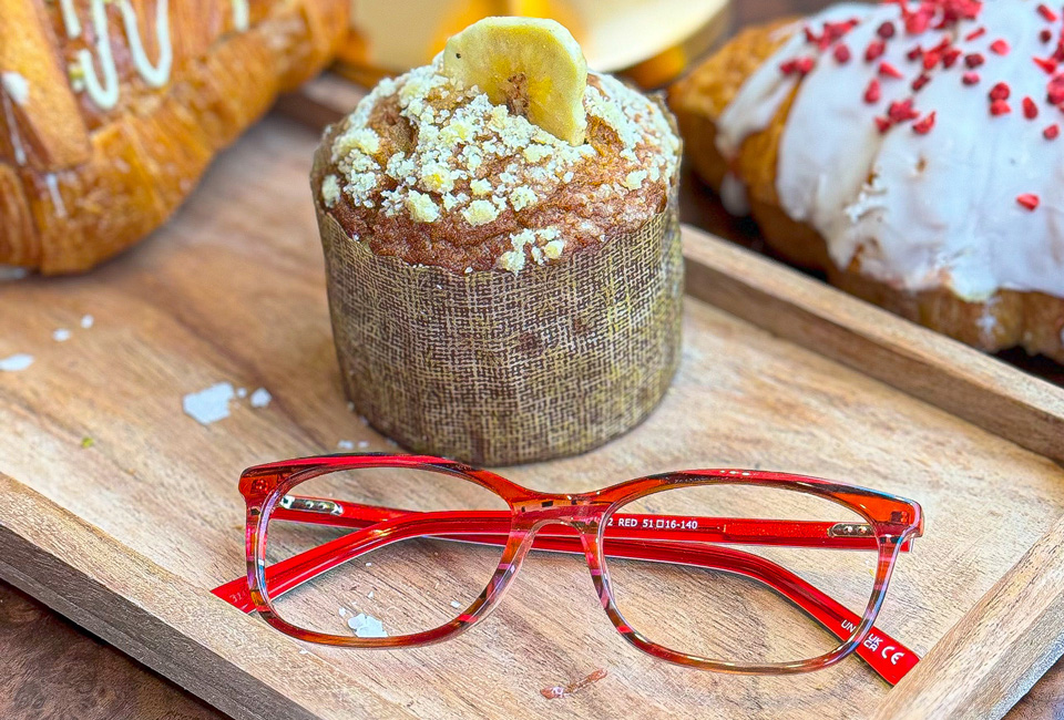 A rectangular red frame rests on a wooden platter in front of some impressive pastries