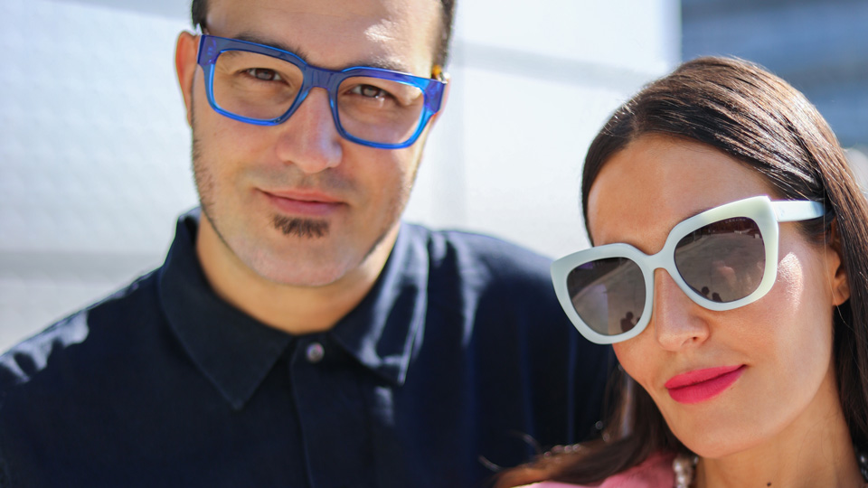 Nuria and Miguel pose in the sunshine wearing circular glasses in white and yellow with bold rounded sides 