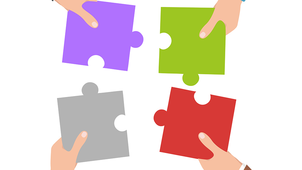 Illustration of four coloured puzzle pieces being put together 