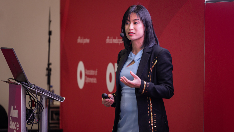 A presenter on the Main Stage at 100% Optical