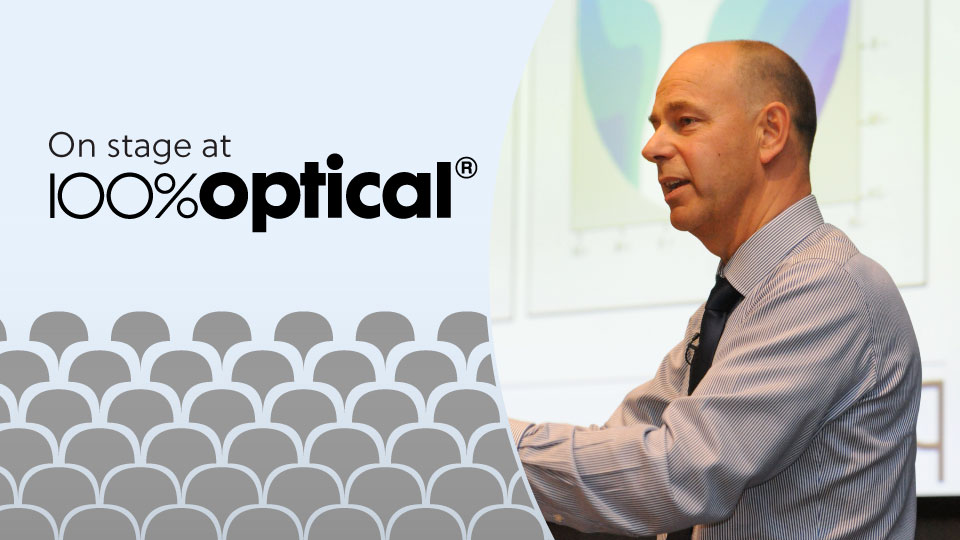 Richard presents on stage from a lecturn