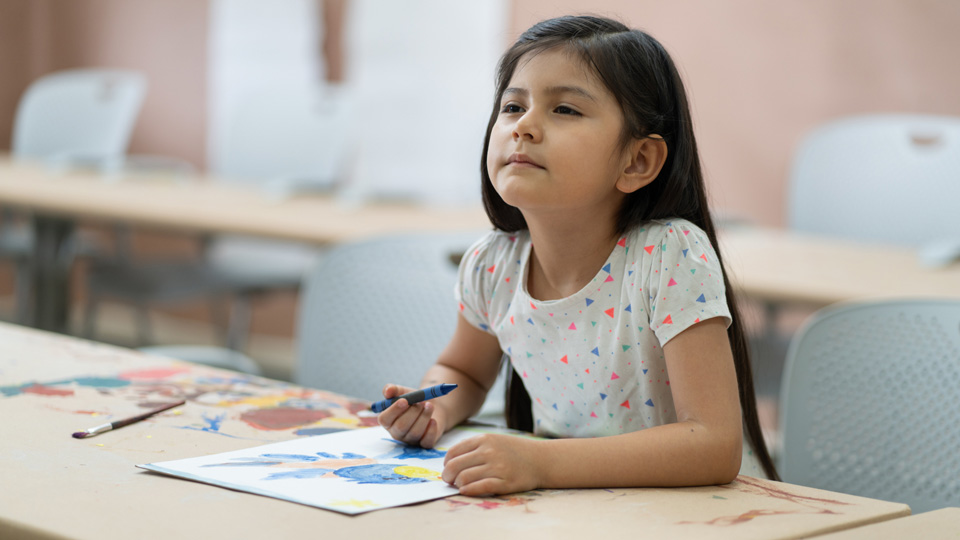 Girl sitting in class and squinting to see board 