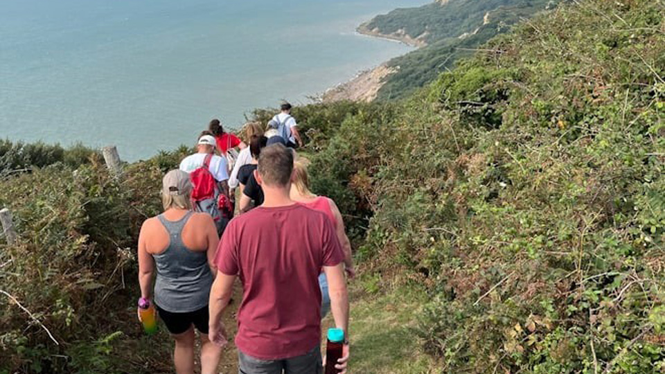 A group walk down a coastal cliff path