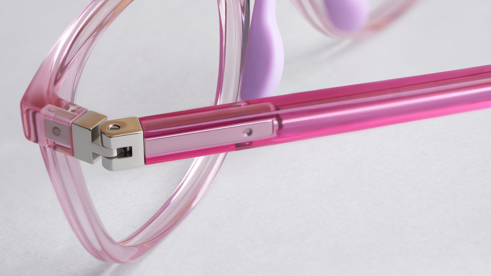 A close up of a bright pink clear frame with metal hinge