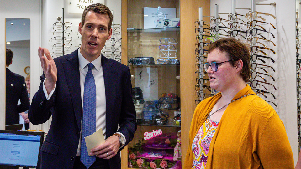 MP for Greenwich and Woolwich, Matthew Pennycook, and SeeAbility expert by experience and eye care champion, Grace McGill, are facing towards the camera whilst speaking inside an optical practice